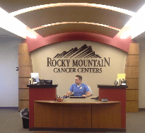 Medical office reception desk with a staff member seated behind it