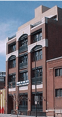 Tall brick loft building with arched windows and balconies